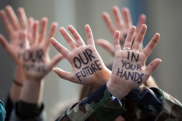 Hands of Gen Z protestors at a march in Belgium in 2019